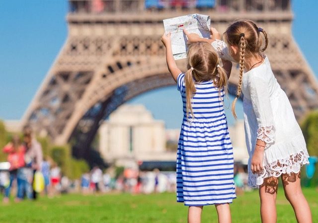 Crianças em frente à Torre Eiffel em Paris