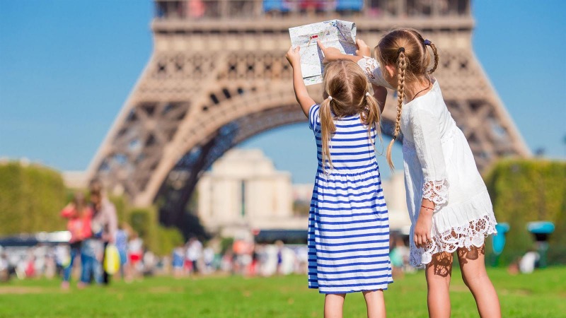 Crianças em frente à Torre Eiffel em Paris