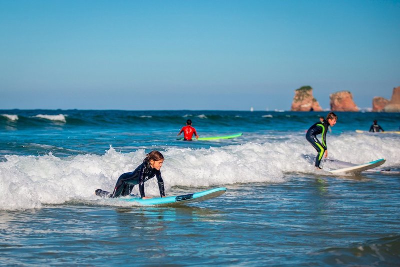 Crianças surfando na praia de Hendaye