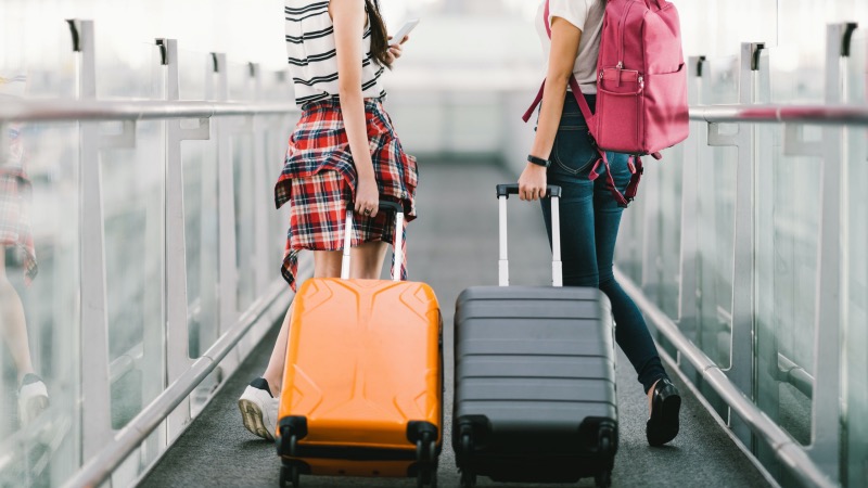 Meninas carregando malas de viagem